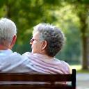 Due persone si parlano con calma su una panchina, simboleggiando la conversazione in un gruppo privato e supportivo.