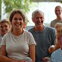 Donne e uomini di diverse età sorridono in un gruppo, rappresentando fasce d'età miste.