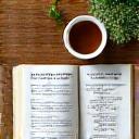 Un quaderno con appunti scritti a mano e una tazza di tè, che simboleggia guide pratiche generate dalla community.