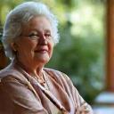 Due donne, una più anziana e una più giovane, sorridono mentre parlano in un ambiente di mentorship.